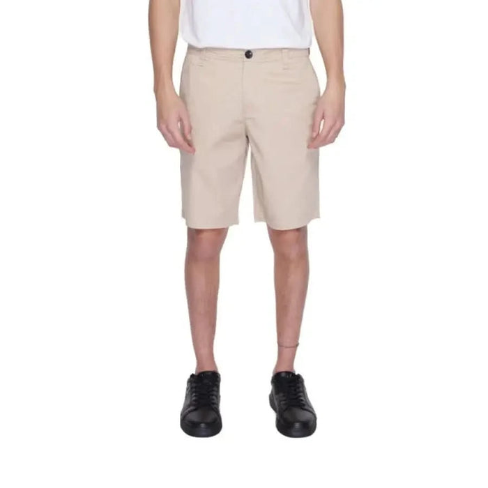 Beige knee-length Armani Exchange shorts paired with black sneakers for men