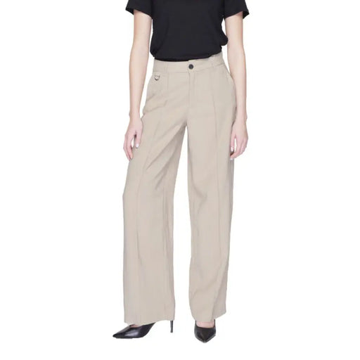 Beige wide-leg trousers paired with a black top from Only Women Trousers collection