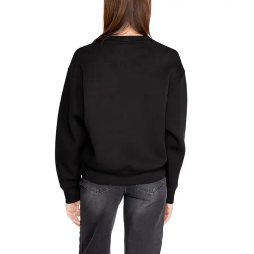 Black crewneck sweater on a woman from behind, part of Guess Active Women Sweatshirts