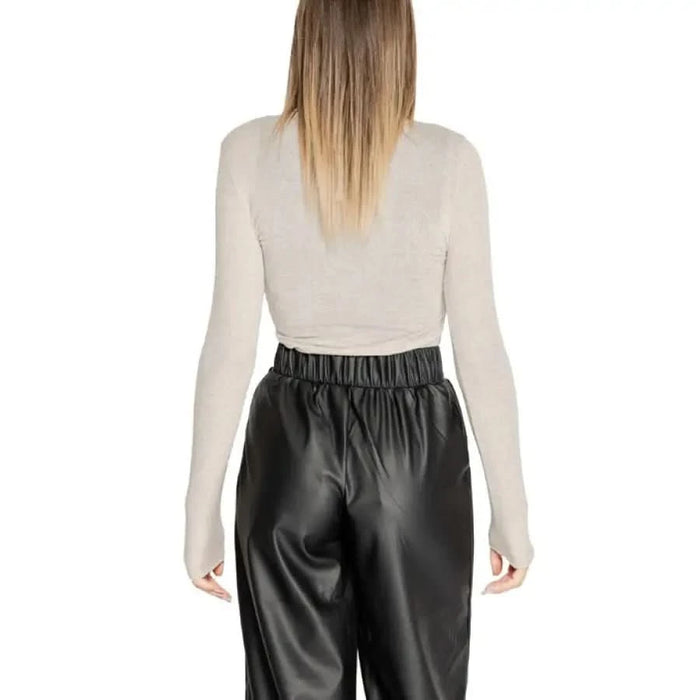 Black faux leather pants with elastic waistband styled with CLERÈ beige long-sleeve top