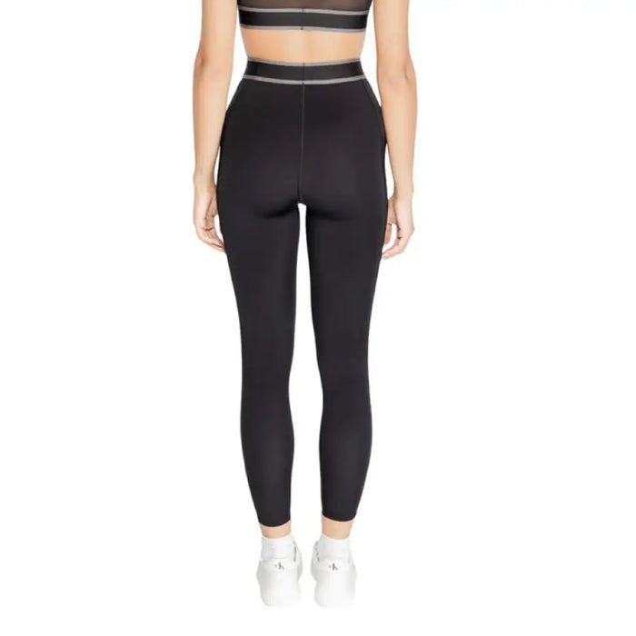 Black high-waisted athletic leggings modeled by a person in Calvin Klein Sport style