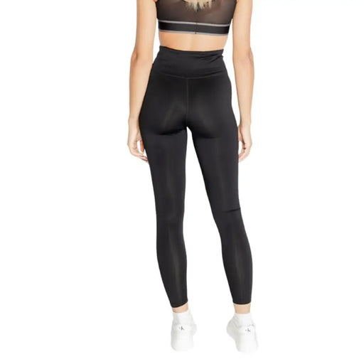 Black high-waisted Calvin Klein Sport leggings worn by a person from the waist down