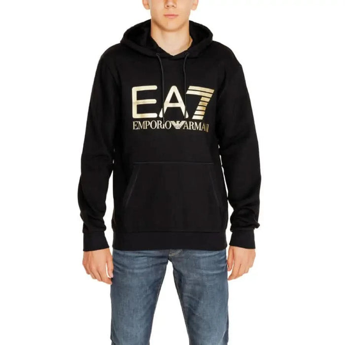 Black hooded sweatshirt with gold EA7 Emporio Armani logo displayed in EA7 Men Sweatshirts