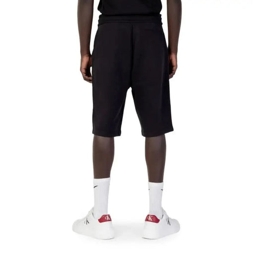 Calvin Klein Jeans Men Shorts in Black knee-length worn by person with dark skin