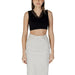 Black lace-trimmed sleeveless crop top with light gray denim skirt for Guess Women’s collection