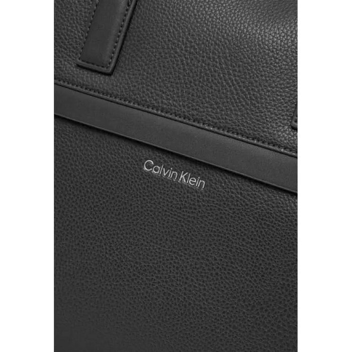 Black leather Calvin Klein bag featuring brand logo, ideal for stylish professionals