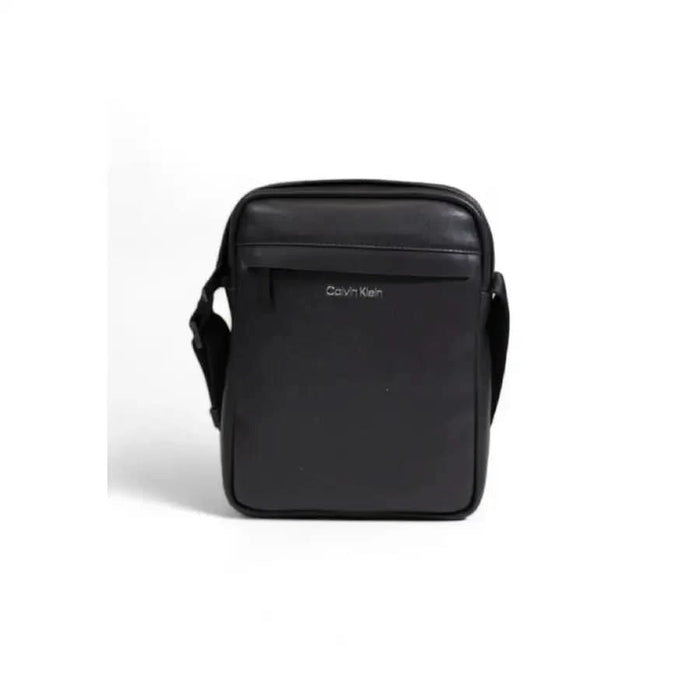 Black leather messenger bag with shoulder strap and front pocket by Calvin Klein