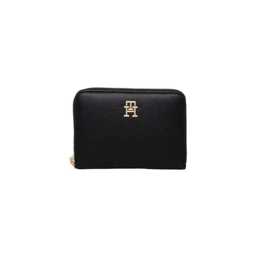 Black leather zip-around wallet with gold monogram logo by Tommy Hilfiger for women