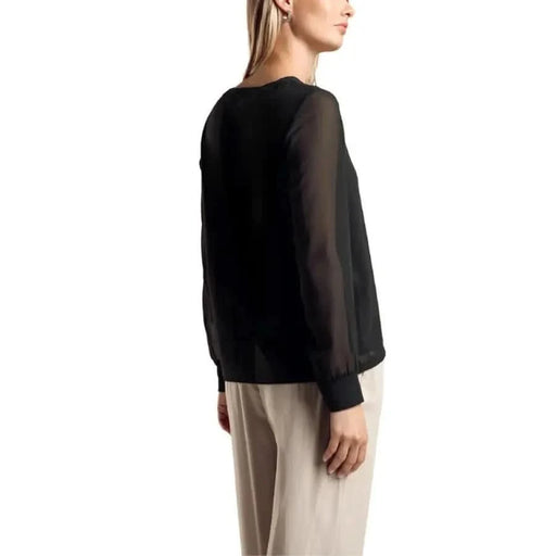 Black long-sleeved blouse with sheer sleeves modeled by a woman from Street One