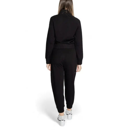 Black long-sleeved Ea7 Women Jumpsuit worn by a person viewed from behind