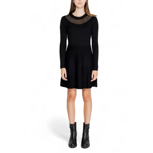 Black long-sleeved knit dress with sheer neckline and flared skirt by Morgan De Toi