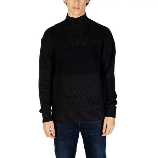 Black ribbed turtleneck sweater paired with dark jeans from Calvin Klein Jeans