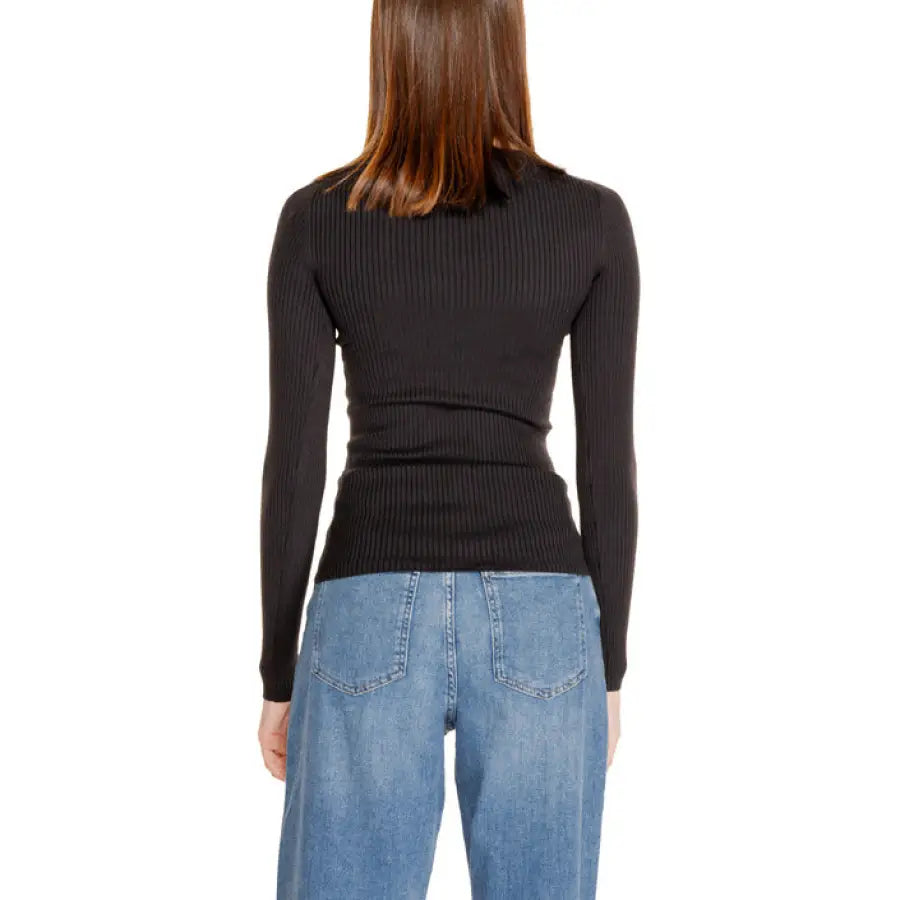 Calvin Klein black ribbed turtleneck sweater with blue jeans from the women’s knitwear line