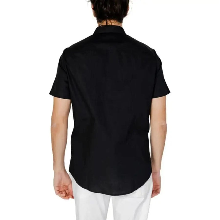 Back view of man in Armani Exchange black short-sleeved button-up shirt