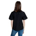 Jacqueline De Yong black short-sleeved shirt worn by woman with long brown hair, back view