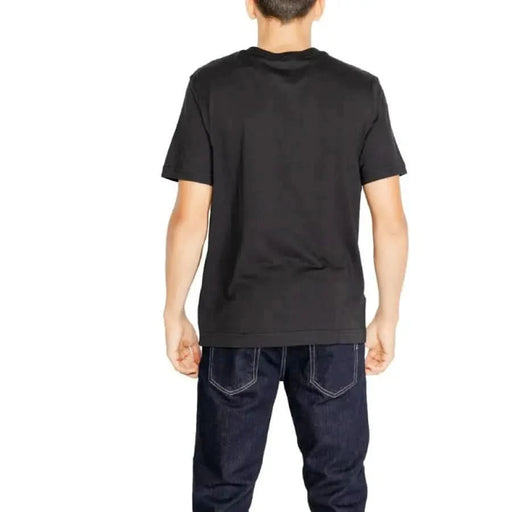 Black short-sleeved Calvin Klein Sport T-shirt worn by a person facing away from the camera