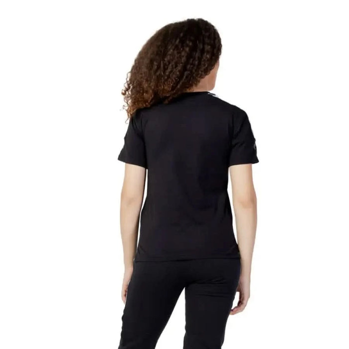 Black short-sleeved Fila Women T-Shirt viewed from behind on a person with curly hair