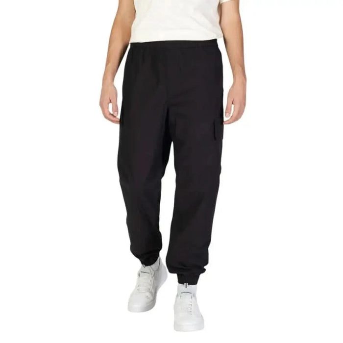 Black Calvin Klein Jeans sweatpants featuring elastic cuffs at the ankles for men