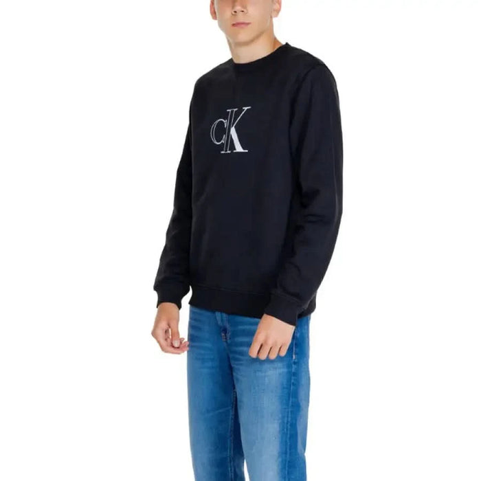 Calvin Klein black sweatshirt with CK logo worn by person in blue jeans