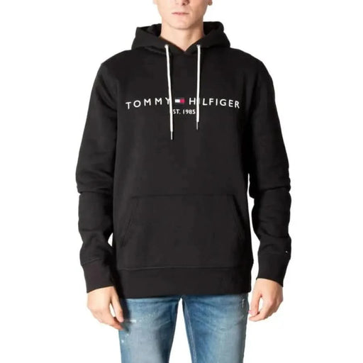 Black Tommy Hilfiger hoodie featuring white logo text across the chest for men