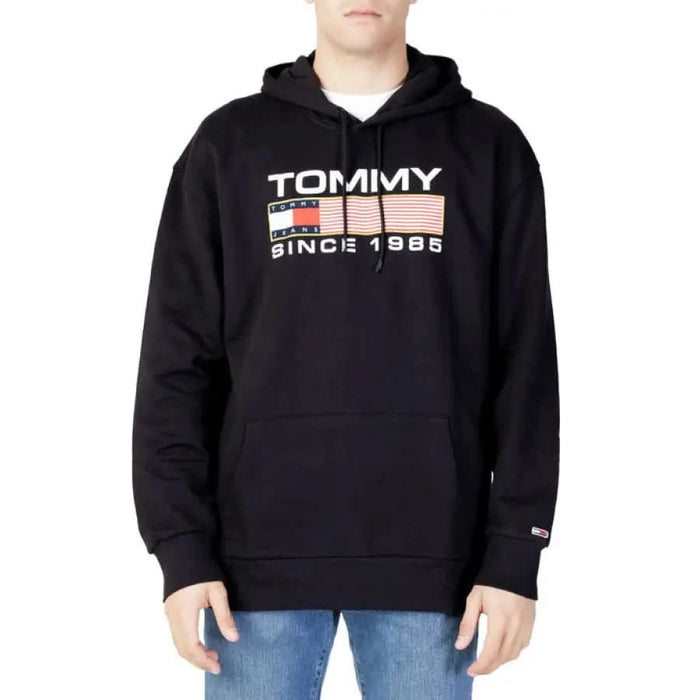 Black Tommy Hilfiger hoodie with TOMMY SINCE 1985 logo front, from Tommy Hilfiger Jeans Men