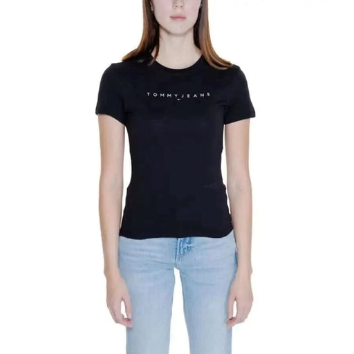 Woman wearing Black Tommy Jeans t-shirt with light blue jeans from Tommy Hilfiger