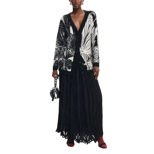 Elegant black and white patterned cardigan layered over a long black dress by Desigual