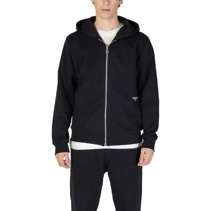 Black zip-up hooded sweatshirt paired with a white undershirt from Underclub