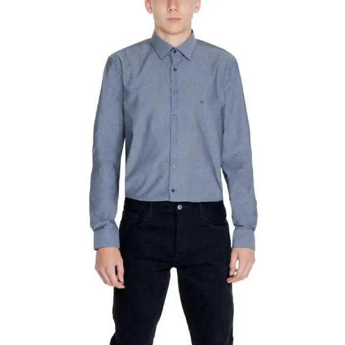 Calvin Klein men’s blue-gray button-up dress shirt paired with dark pants