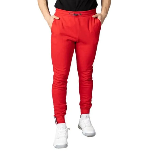 Tommy Hilfiger bright red jogger-style sweatpants with tapered legs and white sneakers