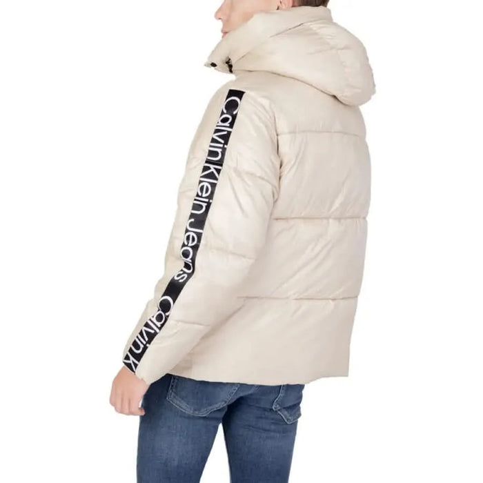 Cream-colored puffer jacket featuring Calvin Klein Jeans text on the sleeve