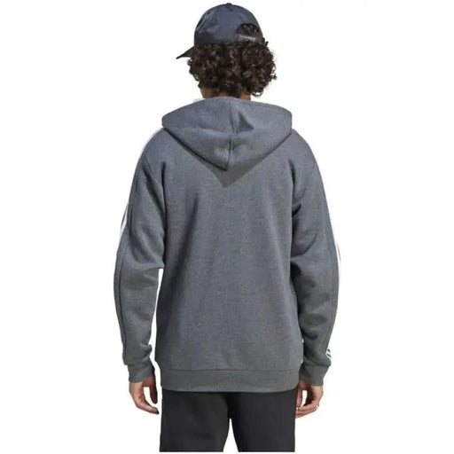 Gray Adidas sweatshirt on a person with curly hair and a baseball cap