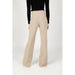 High-waisted beige flared trousers with a black long-sleeved top by Silence