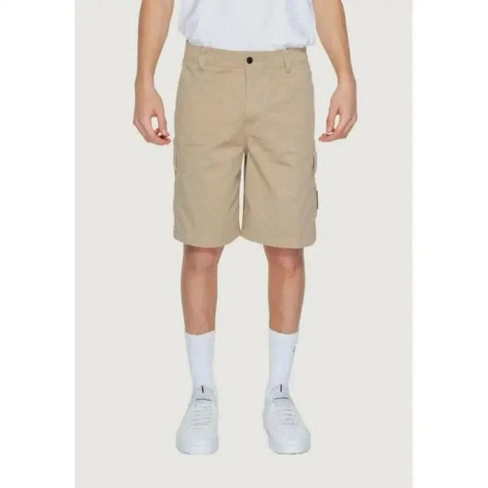 Khaki cargo shorts by Calvin Klein Jeans worn with white shirt and sneakers