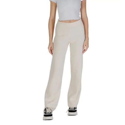 Light beige wide-leg pants with a white crop top and sneakers from Vero Moda