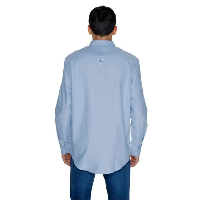 Light blue button-up Tommy Hilfiger dress shirt worn by a person facing away