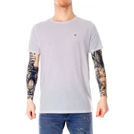 Light gray Tommy Hilfiger t-shirt modeled by individual with heavily tattooed arms