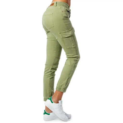 Light green cargo pants with tapered legs and side pockets paired with white sneakers