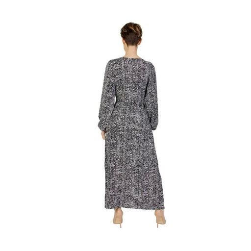 Long-sleeved maxi dress with black and white pattern worn by model from behind