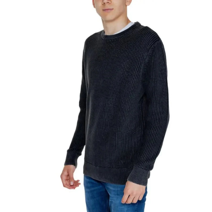 Man in black sweater and jeans from Guess Men Knitwear collection