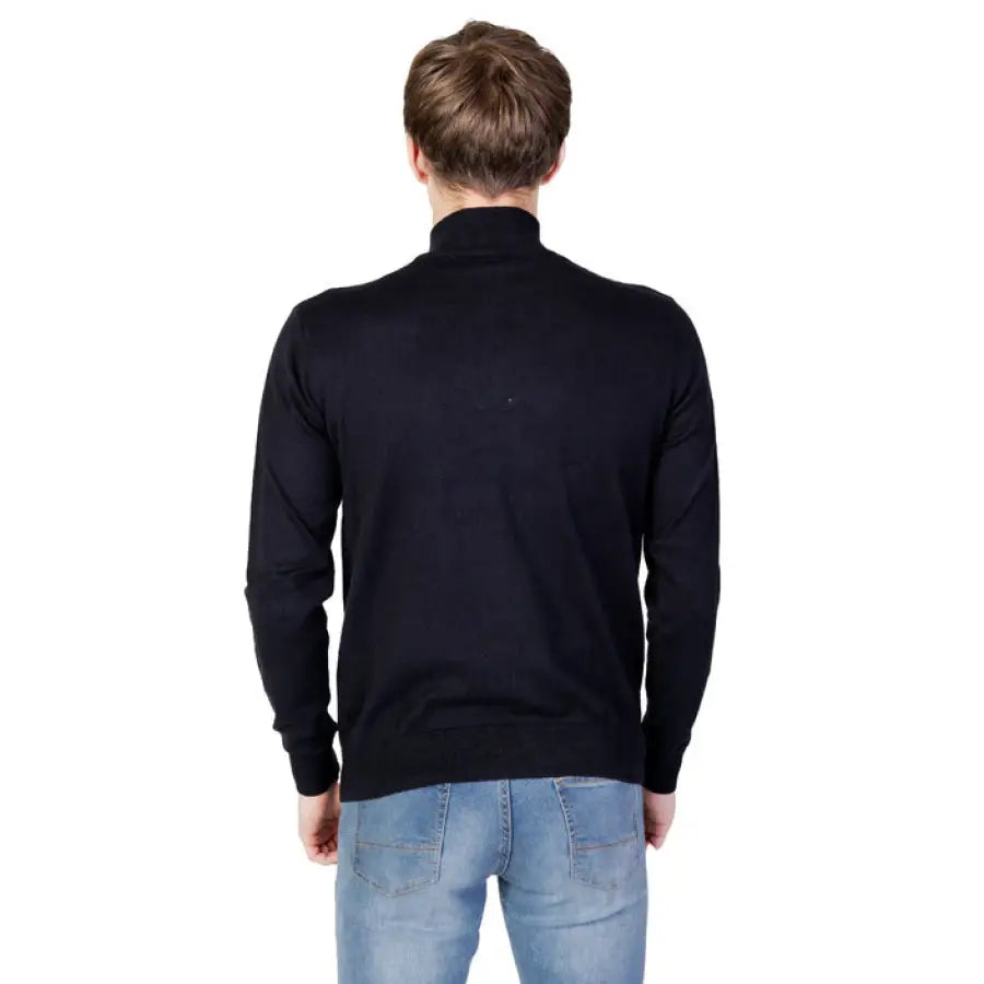 Man wearing U.s. Polo Assn. black sweater and jeans from the Men Knitwear collection