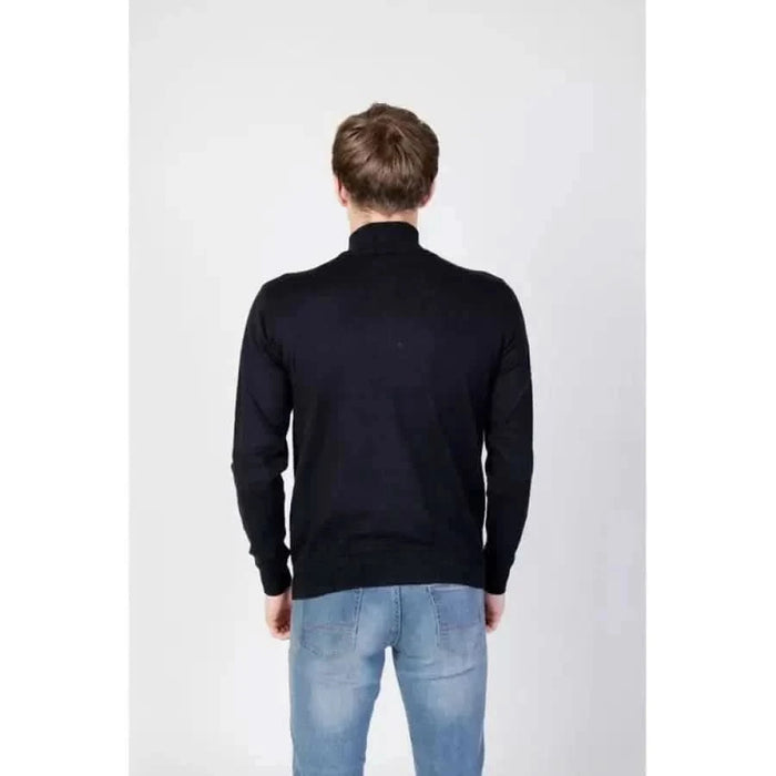 Man wearing U.S. Polo Assn. black sweater and jeans from U.S. Polo Assn. Men Knitwear range