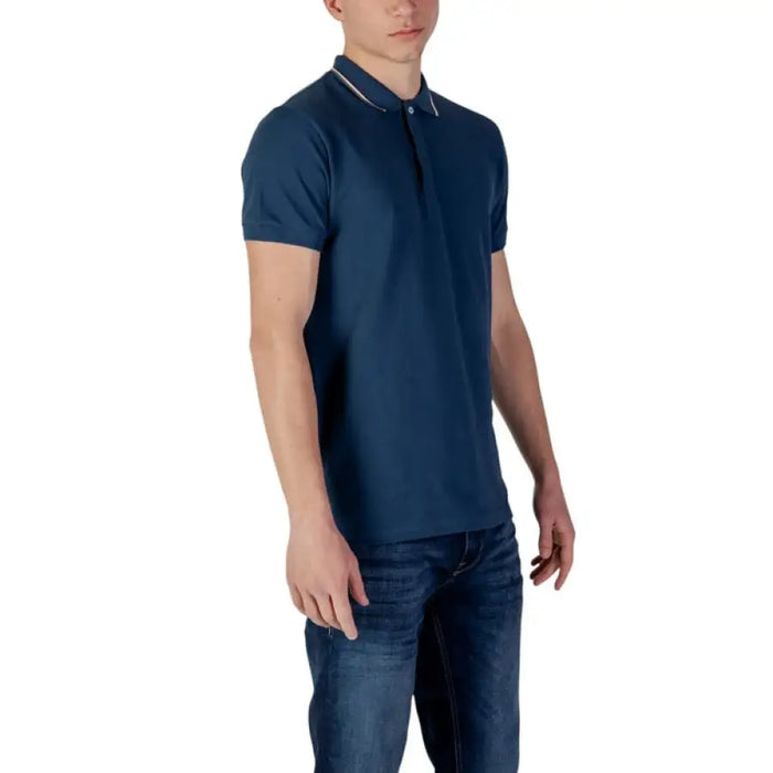 Man wearing Colmar Originals Men’s Blue Polo Shirt with jeans, showcasing casual style