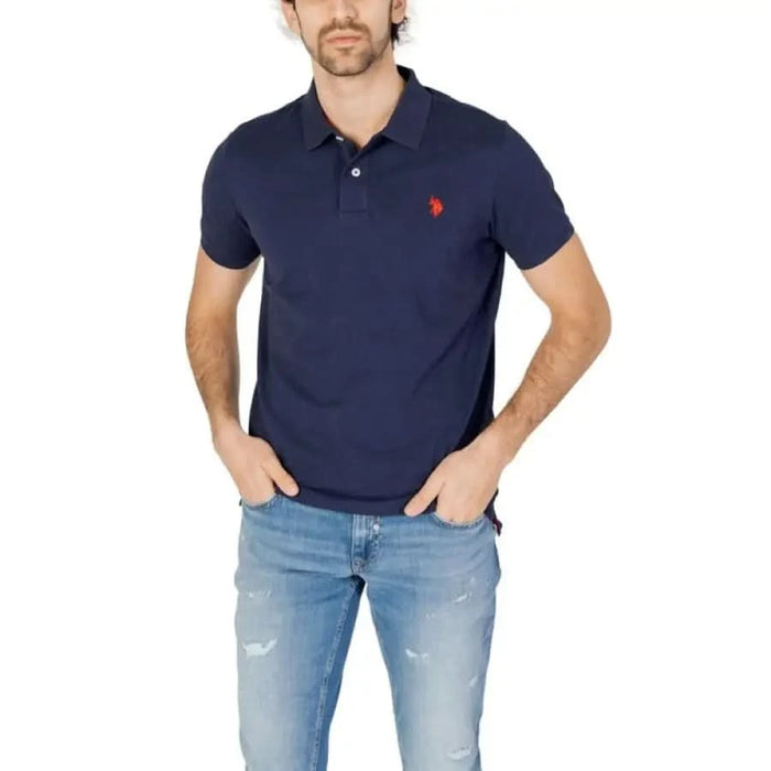 Man in blue U.S. Polo Assn. shirt, jeans showcasing men polo apparel & accessories.