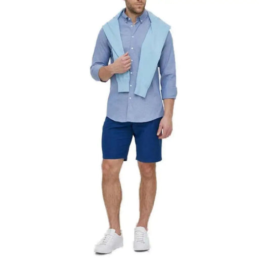 Man in light blue button-down shirt, navy shorts, and draped sweater - Calvin Klein Men Shirt