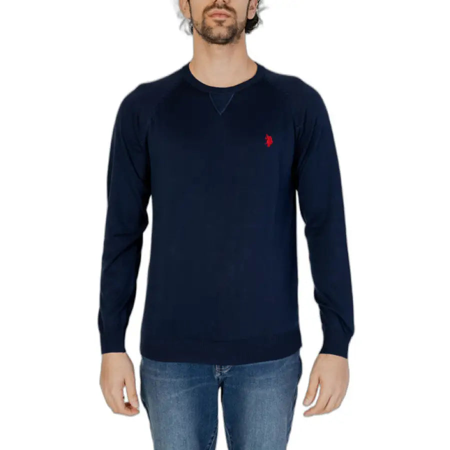 Man wearing a navy U.S. Polo Assn. sweater with a red heart on the chest