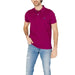 Man in U.S. Polo Assn. pink polo shirt and jeans, showcasing men’s polo apparel accessories.