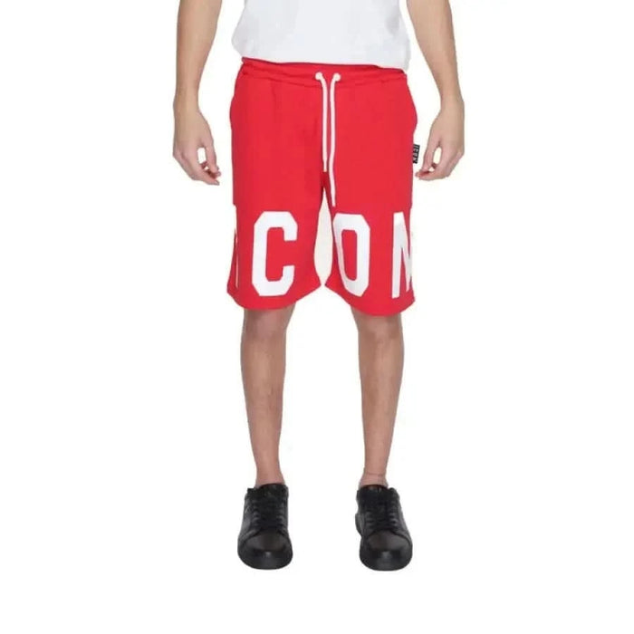 Man wearing Icon urban style clothing, red shorts with white letters, showcasing urban city style