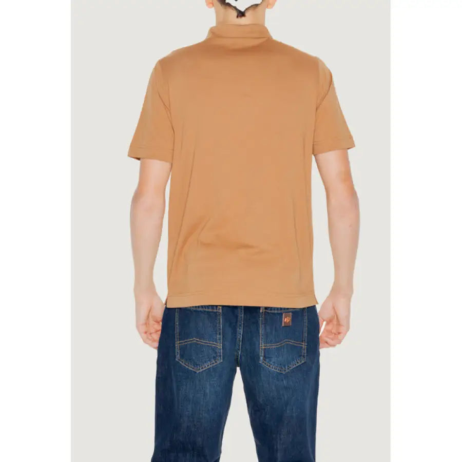 Man wearing tan polo shirt and jeans from Diktat Men Polo collection