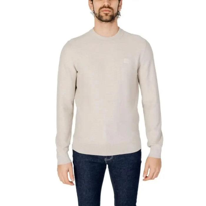 Man in a white sweater and jeans from ’Boss - Boss Men Knitwear’ collection